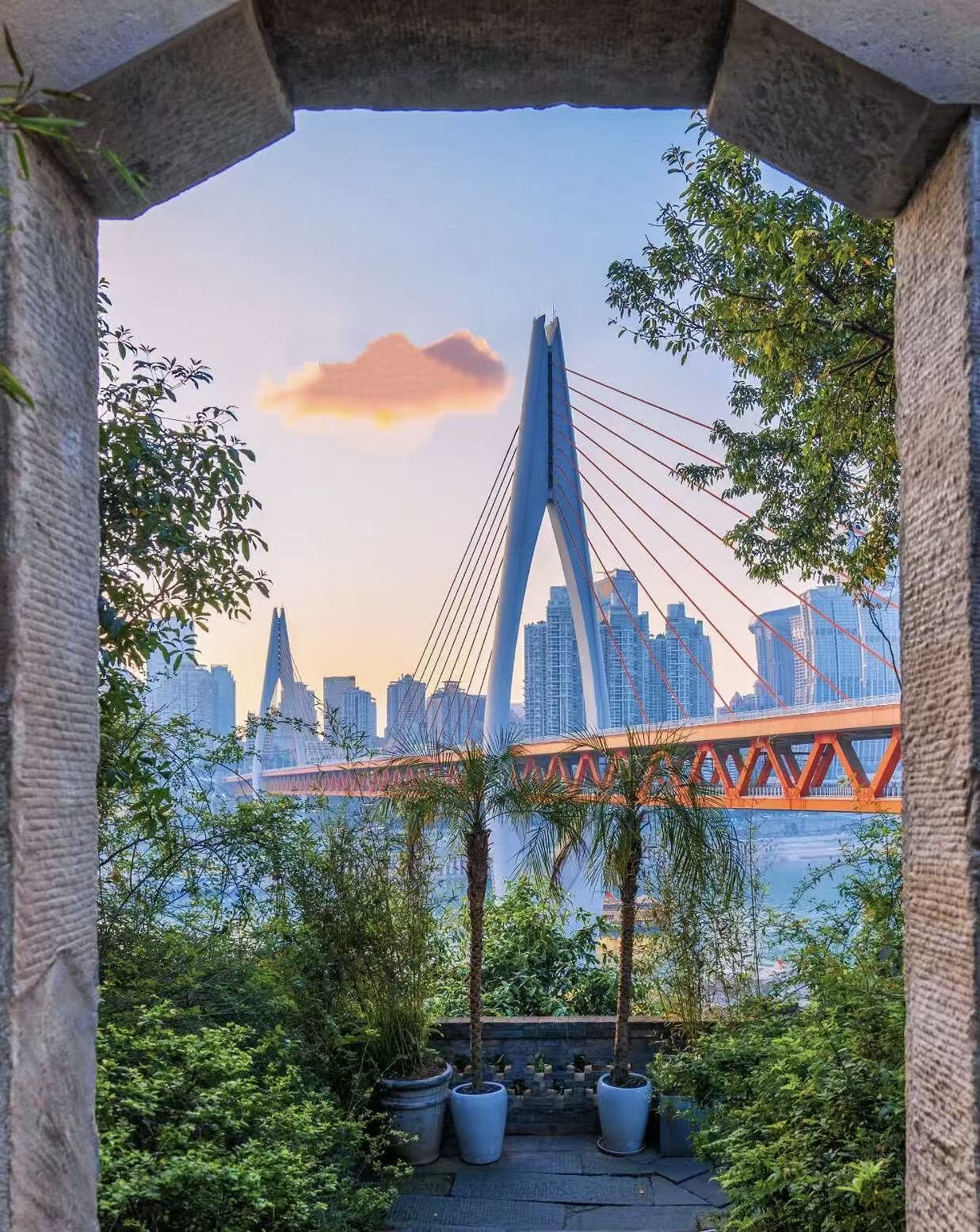 A Chongqing river bridge framed by a hillside garden